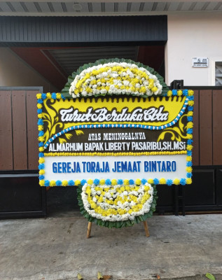 Papan Bunga Duka di Pagar Dewa